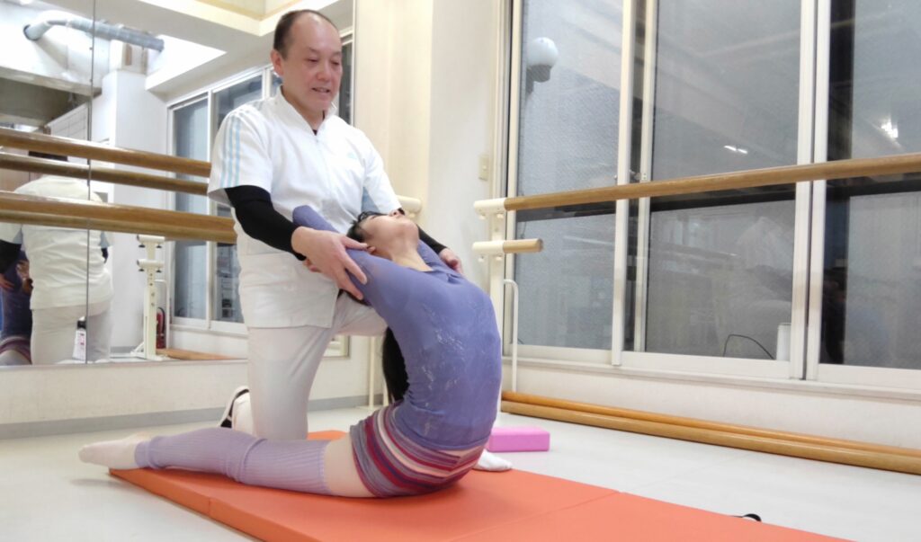 プロのバレエダンサーに対するオーバーストレッチの補助サポートをするバレエ整体師